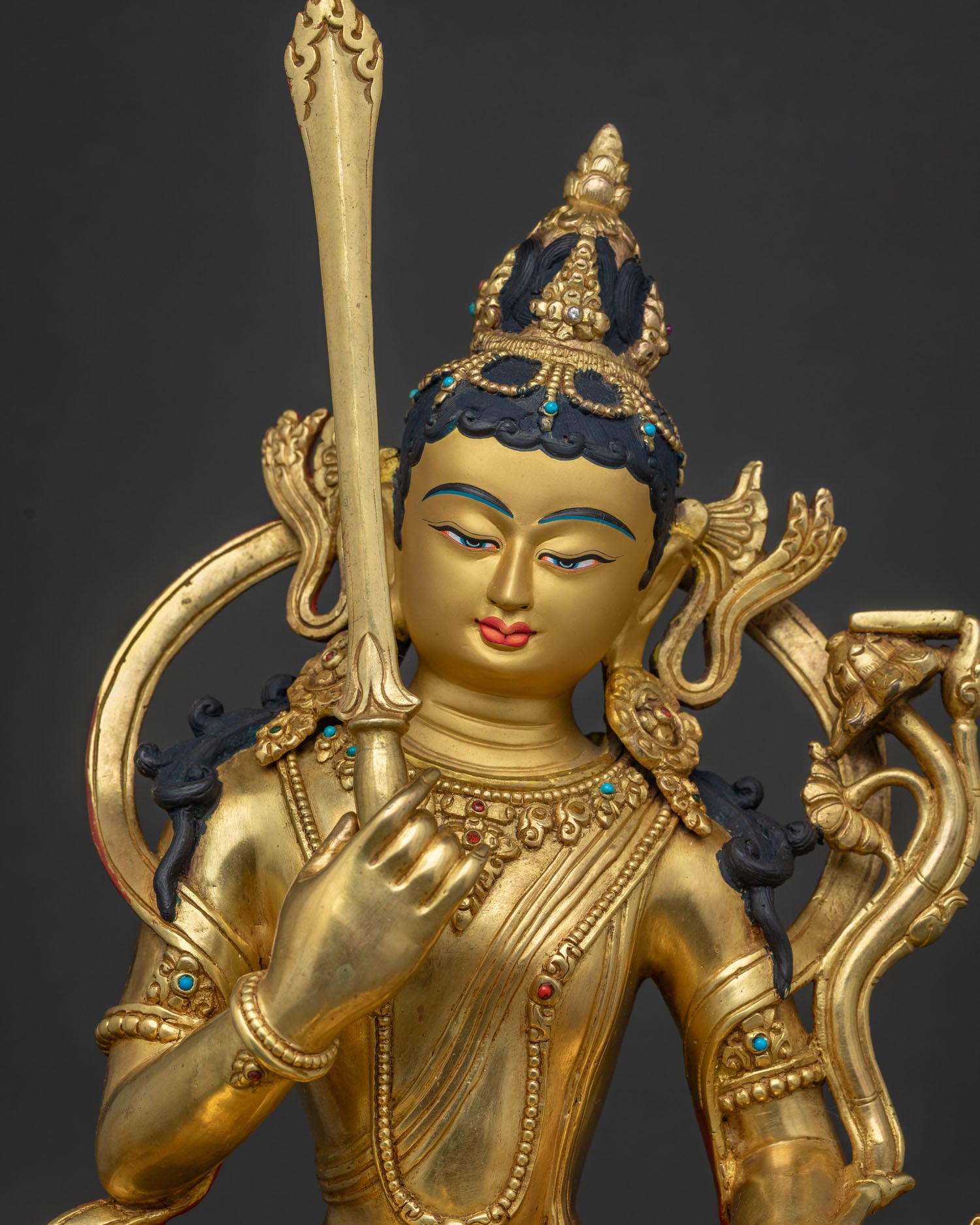 Close-up of gold-gilded Manjushri Statue with fine Tibetan metalwork and gemstone inlays