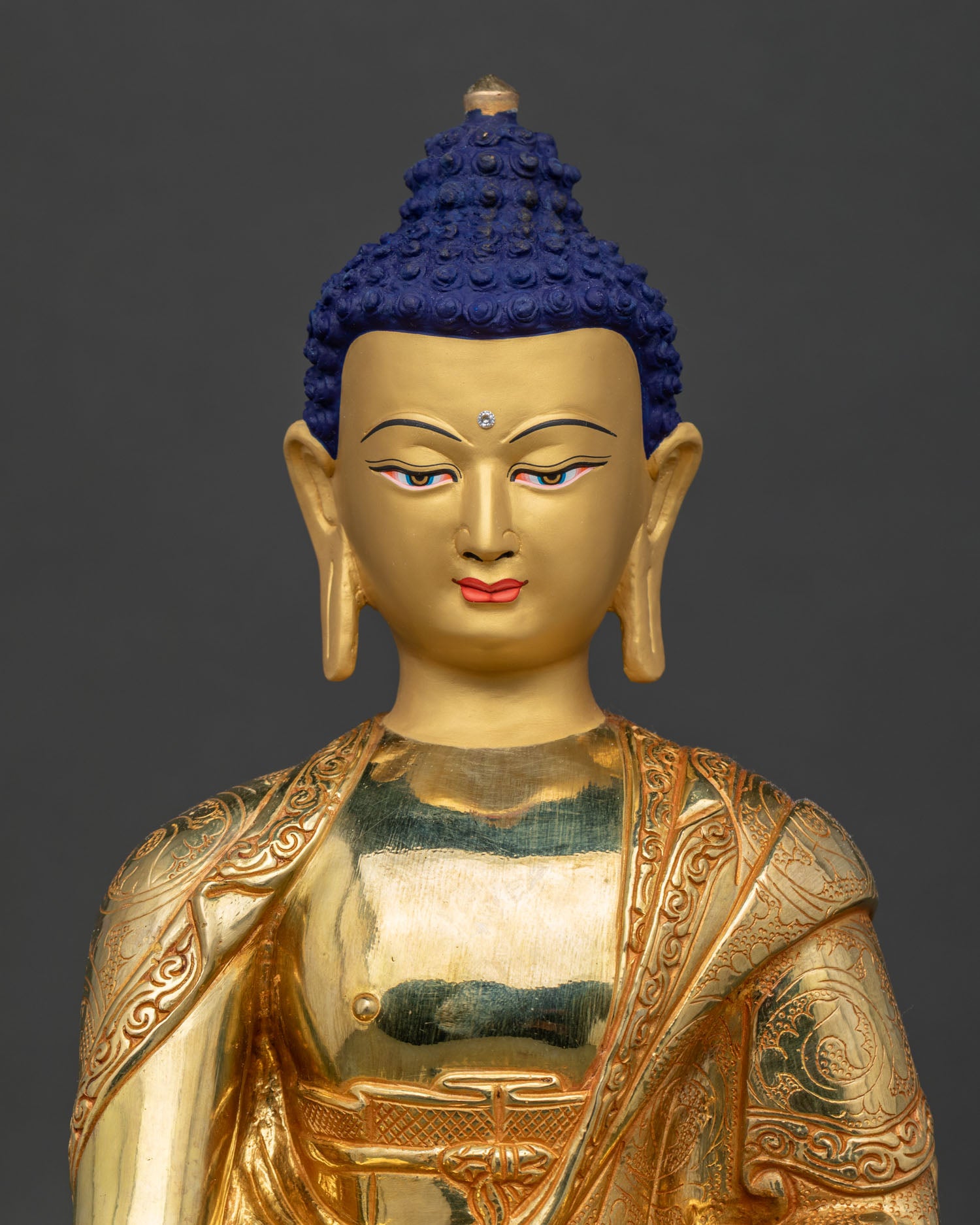Close-up of gold-gilded Shakyamuni Buddha Statue showing repoussé robe detailing and patra bowl