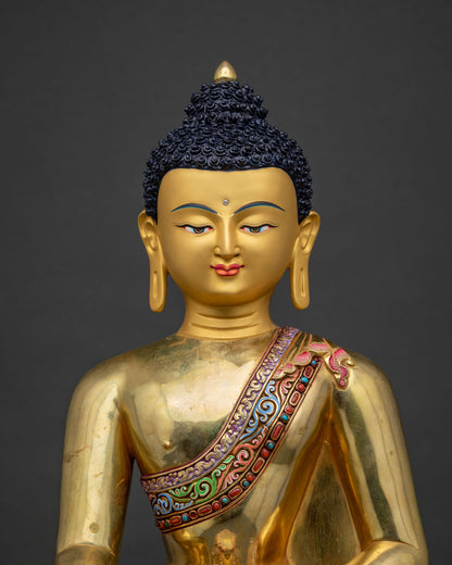 Close up of gold-gilded Shakyamuni Buddha statue with hand-painted monastic robe