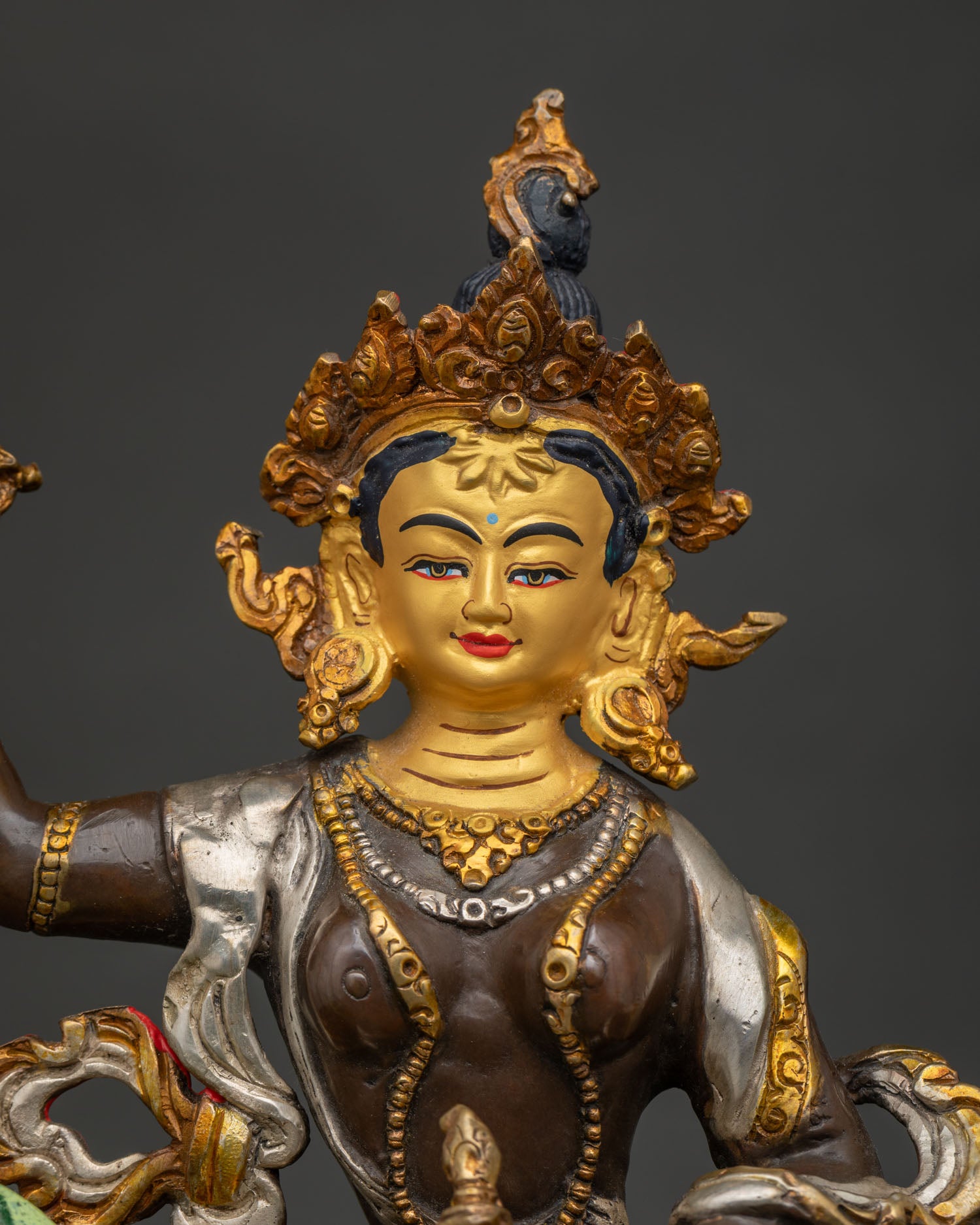 Close-up of gold-gilded Tsheringma statue with lotus throne & snow lion