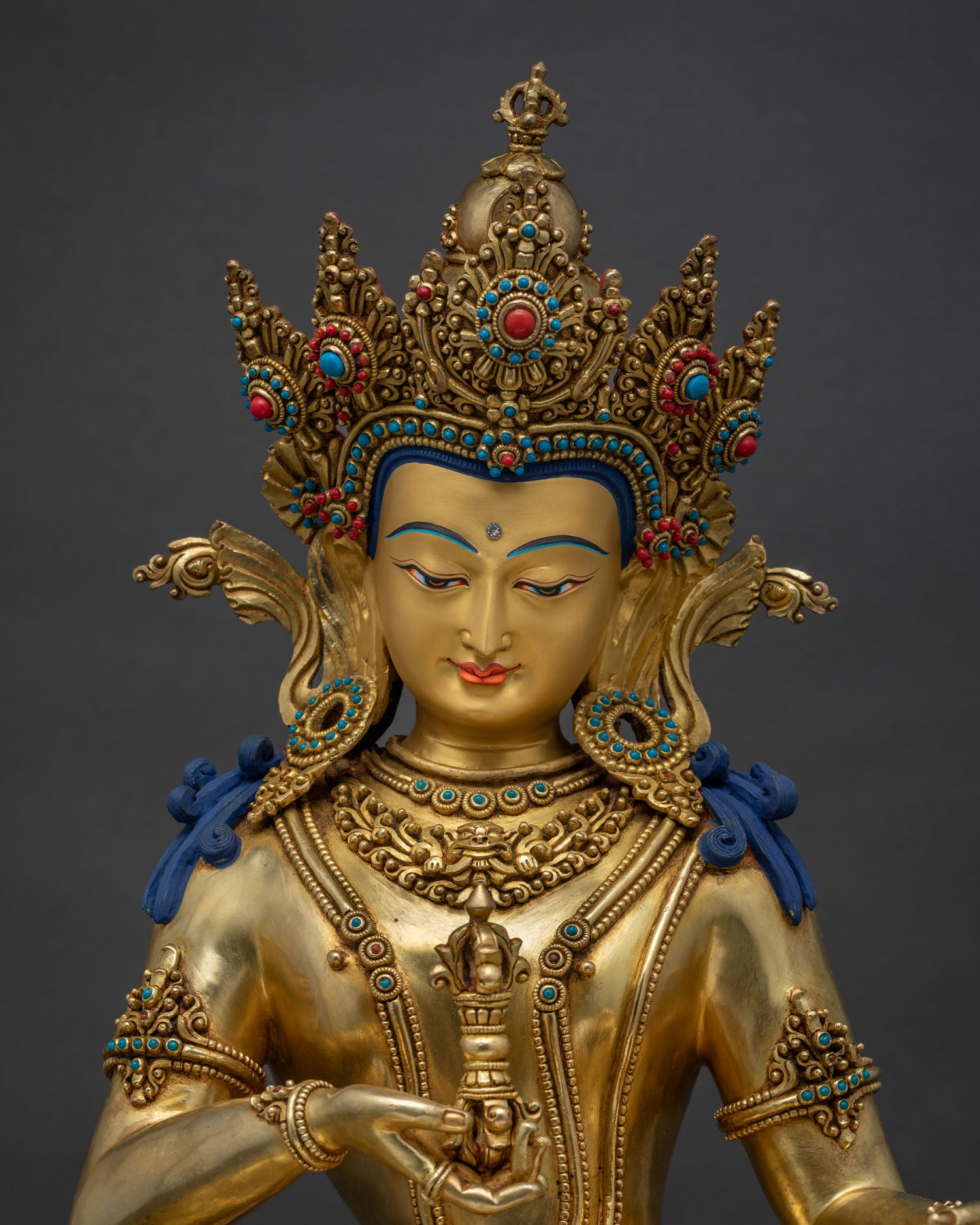 Close-up of gold-gilded Vajrasattva statue showing turquoise and coral inlay work