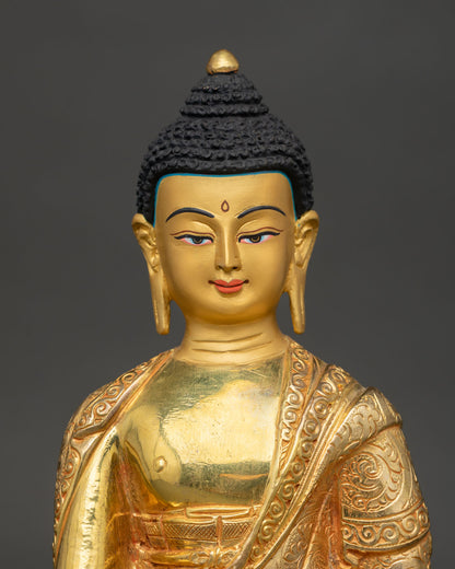Close-up of gold-painted face and floral robe details on the Shakyamuni Buddha statue