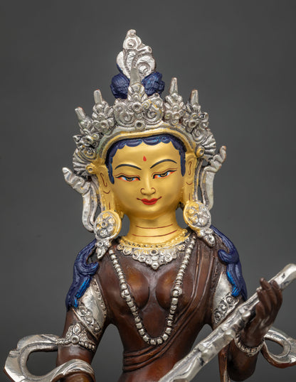 Close-up of gold-painted face and silver crown on oxidized copper Saraswati statue from Nepal