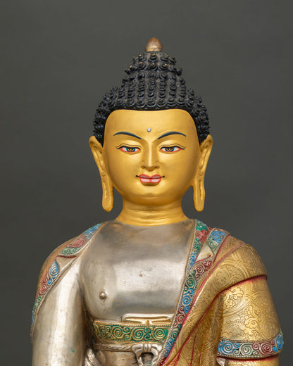 Close-up view of the gold-painted face of the Buddha Shakyamuni statue showing a serene expression