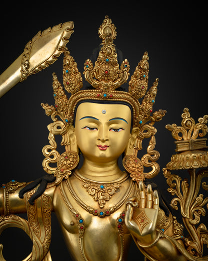 Close-up of gold-painted face with ornate crown, turquoise and coral jewelry on Manjushri statue