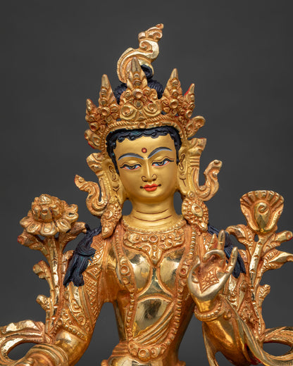 Close up of Green Tara 24k gold painted face with serene expression and ornate jewelry.