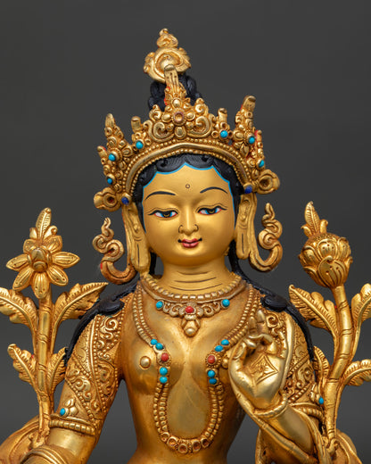Close-up of Green Tara Buddhist statue with gold gilded details and sacred ornaments