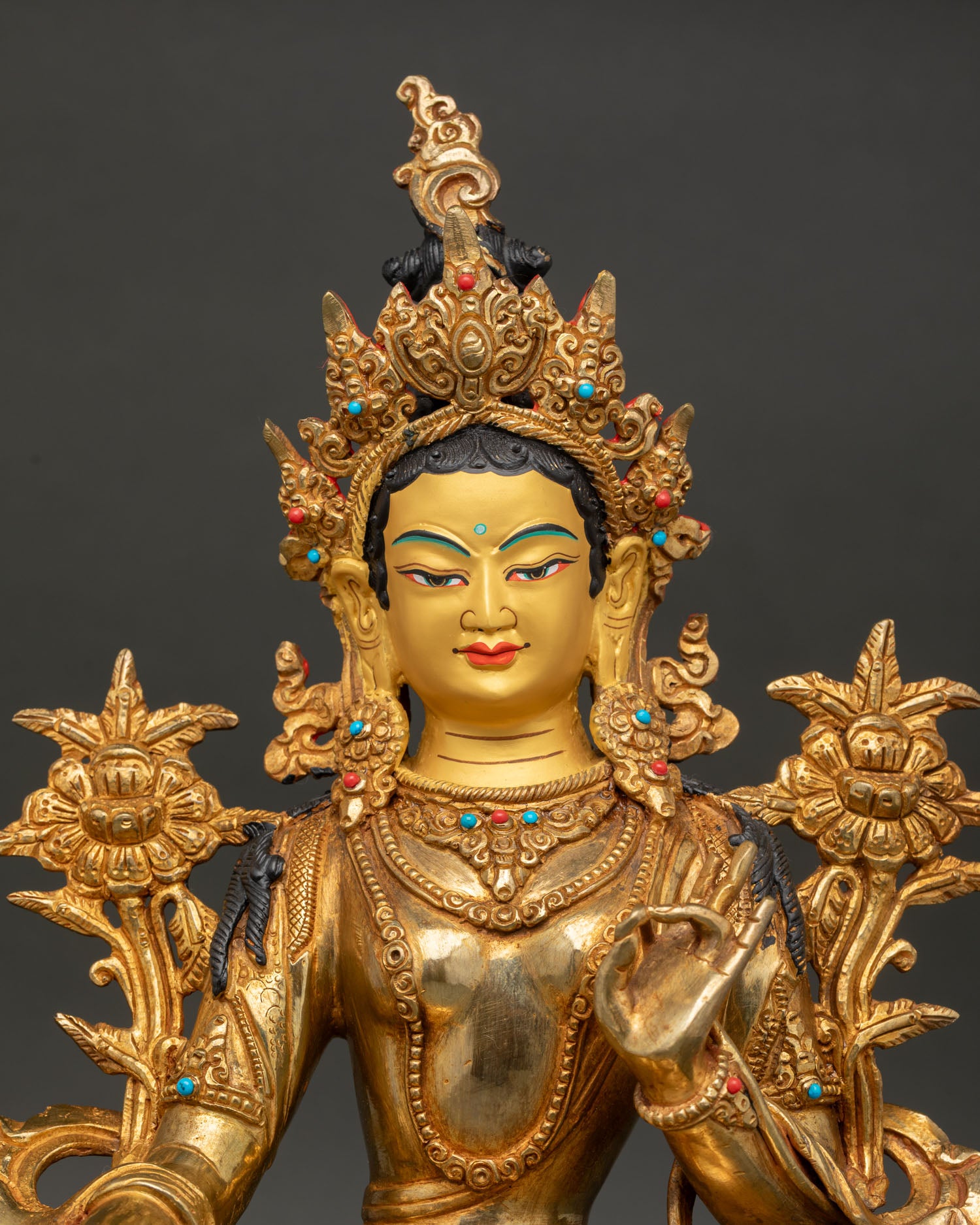 Close-up of Green Tara face with five-jeweled crown and fire-gilded finish.