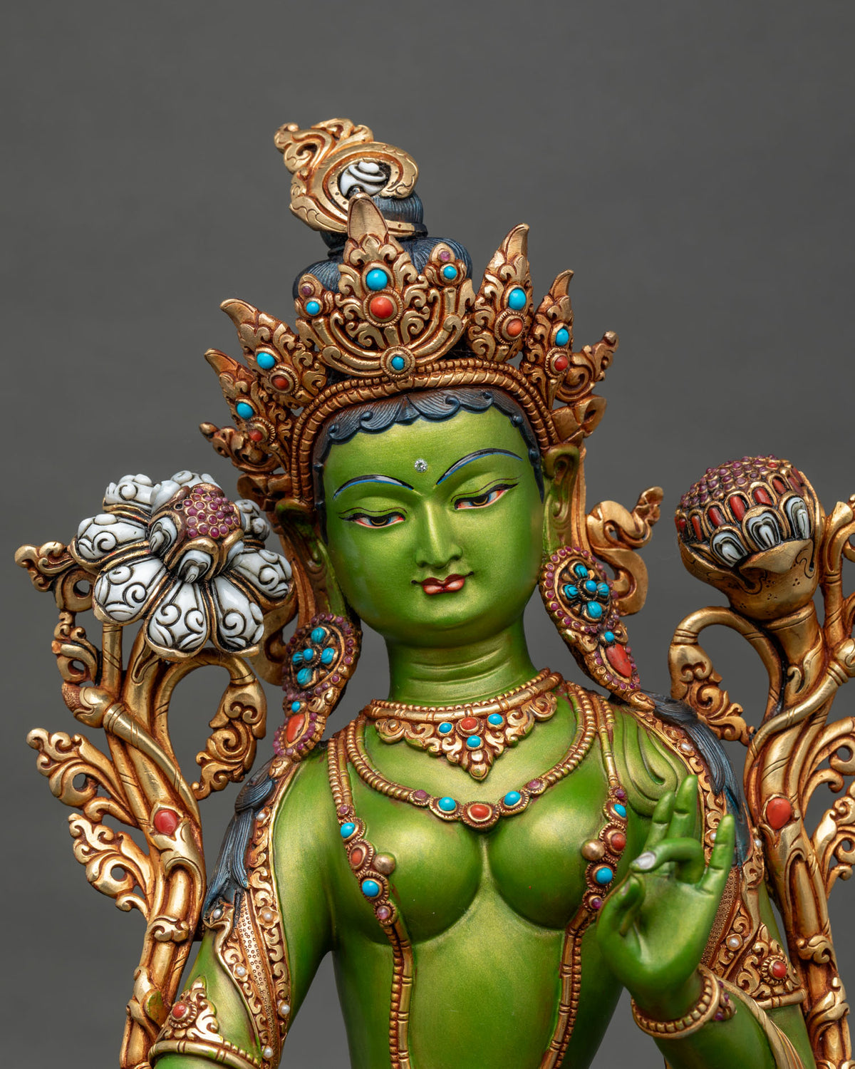Close-up of Green Tara face with ornate gold crown, turquoise inlays and white lotus flower
