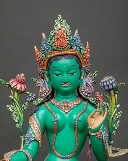 Close up of Green Tara face with vibrant hand painted details and serene expression