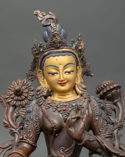 Close up of Green Tara gold painted face with oxidized copper finish and gemstone details.
