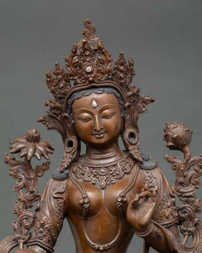 Close up of Green Tara sculpture with oxidized copper finish and ornate crown