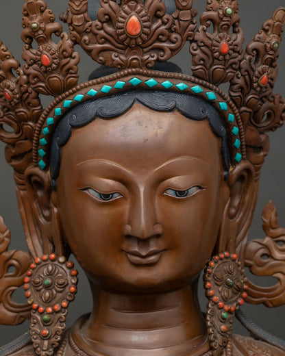Close-up of Green Tara statue's face showing hand-painted eyes and tiered crown