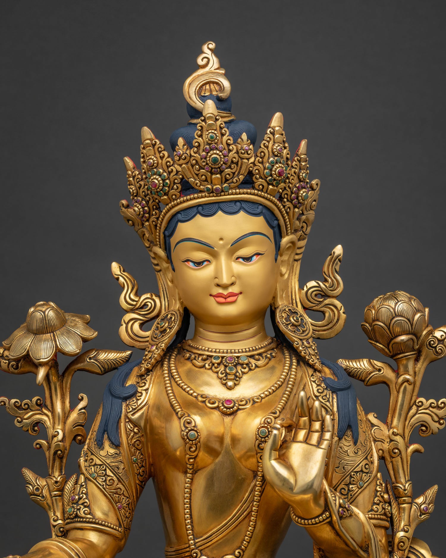 Close-up of Green Tara statue, gold-gilded copper sculpture with lotus flowers