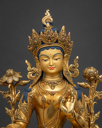 Close-up of Green Tara statue, gold-gilded copper sculpture with lotus flowers