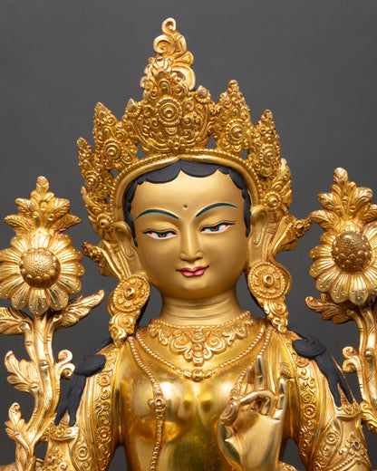 Close up of Green Tara statue gold painted face and semi-precious stones