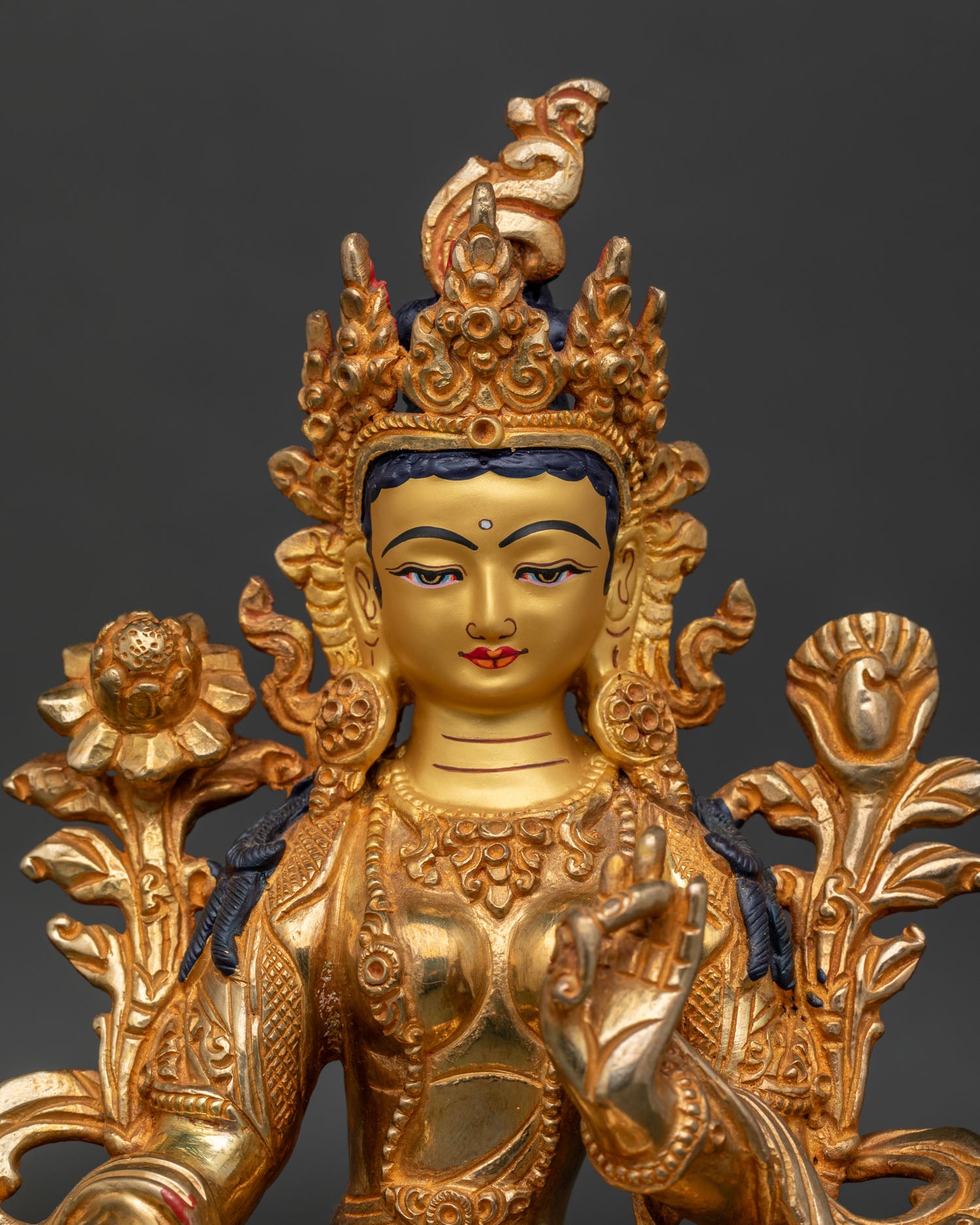 Close Up of Green Tara Statue Gold Painted Face Compassionate Expression.