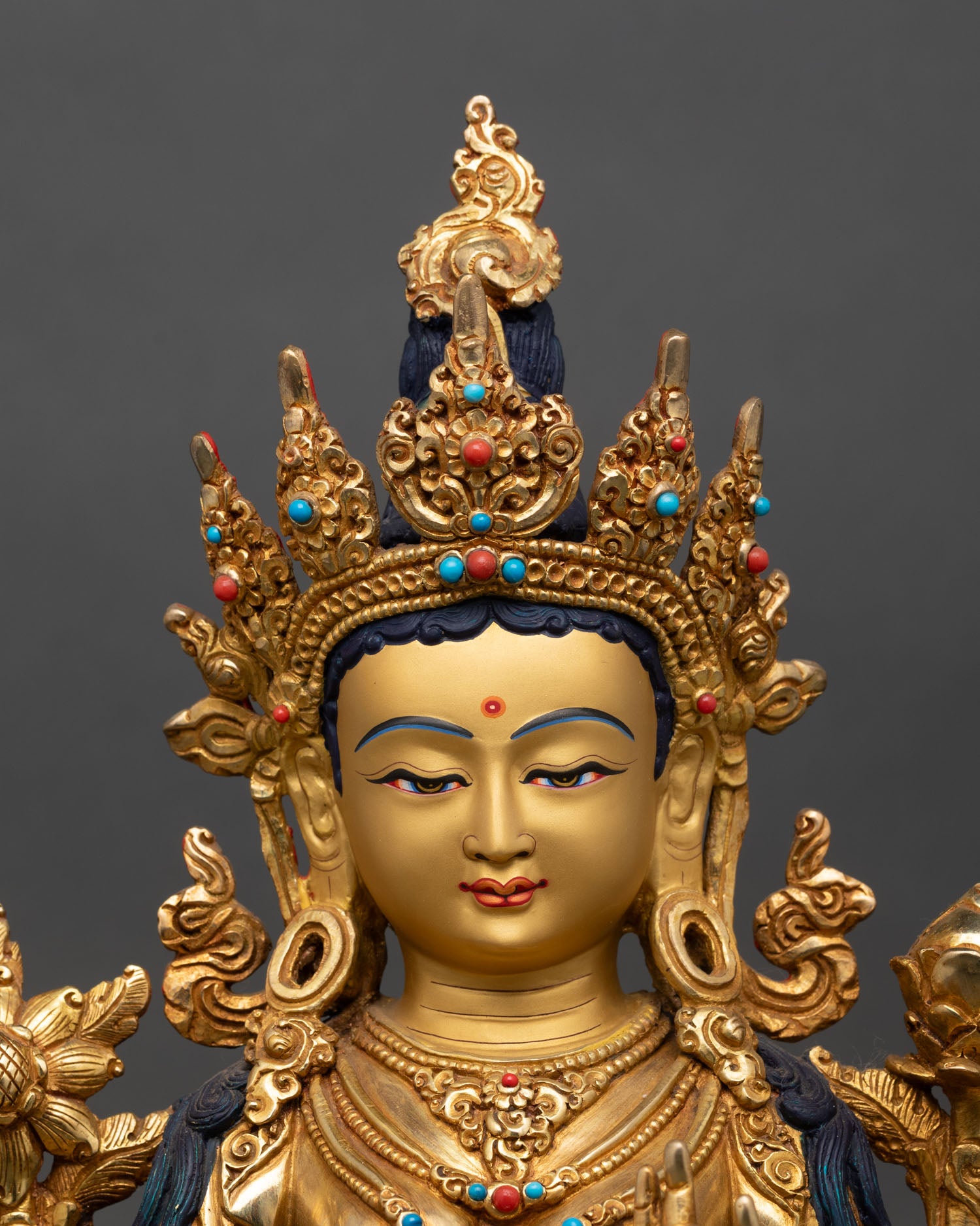 Close up of Green Tara statue gold painted face intricate details copper