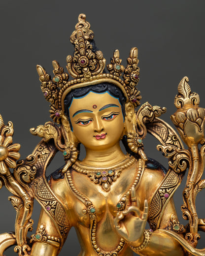 close up of green tara statue highlighting intricate copper craftsmanship and radiant gold gilded finish