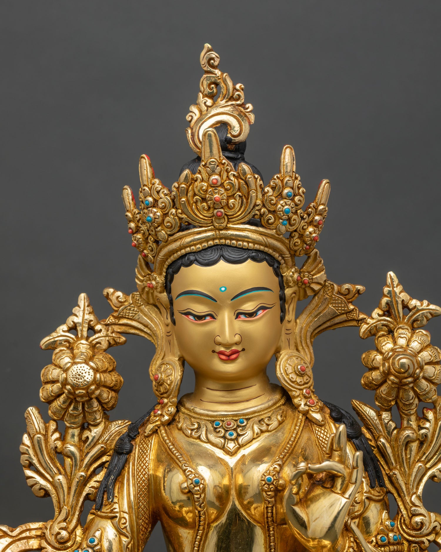 Close-up of Green Tara statue showing gold gilding and intricate lotus details