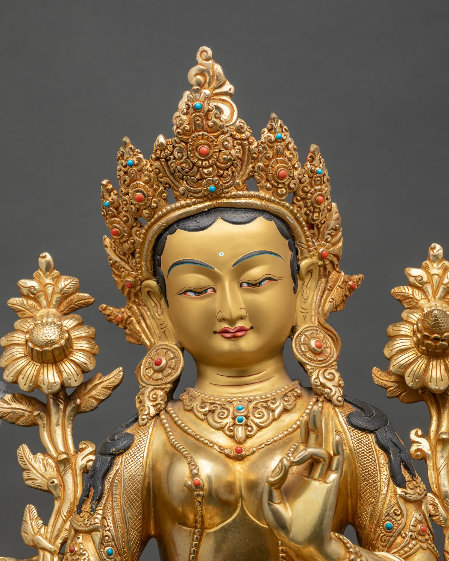 Close-up of Green Tara statue showing intricate copper and gold details