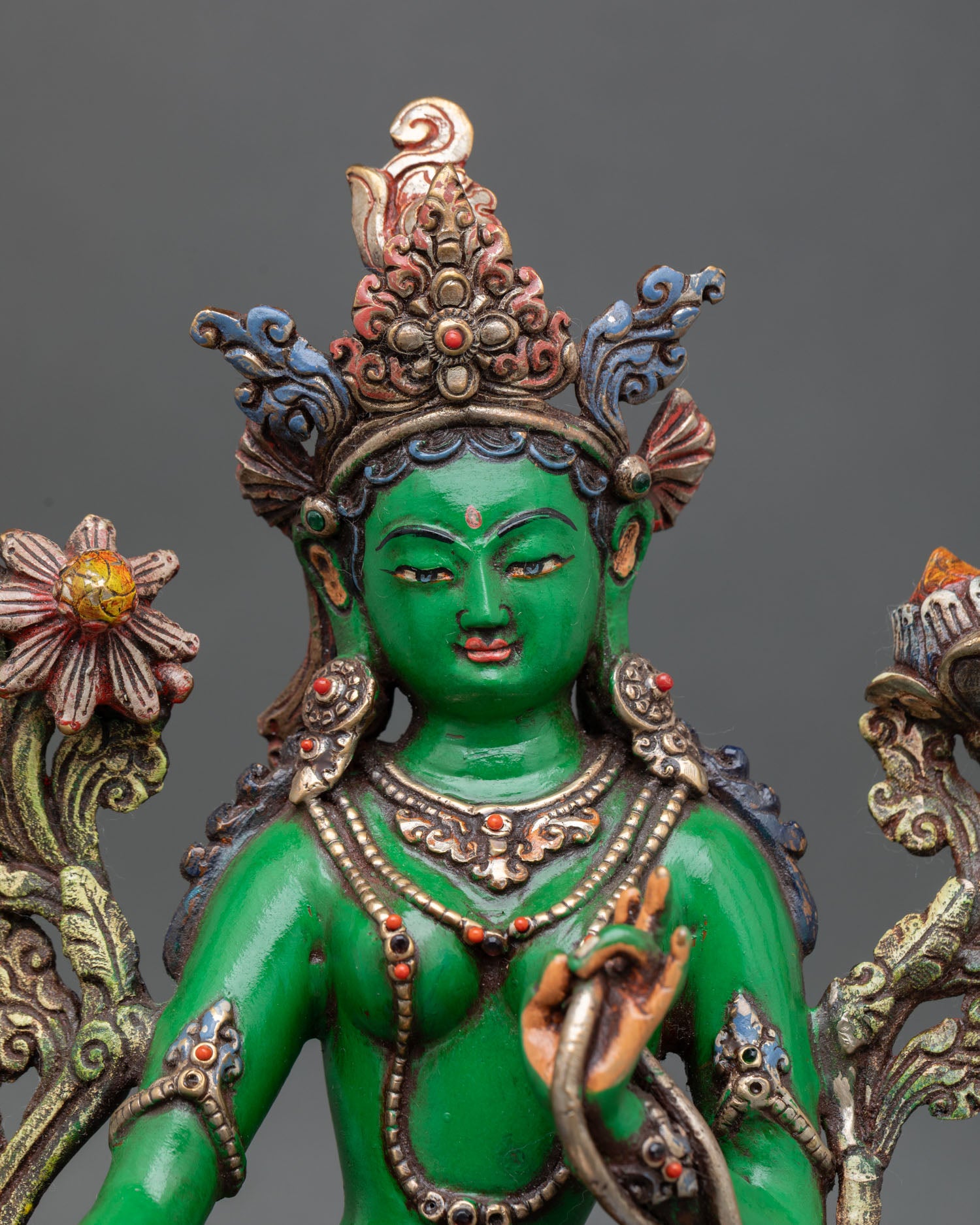 close-up of green tara statue with acrylic colors and handcrafted copper artwork