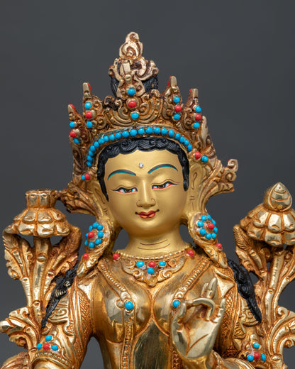 Close up of Green Tara statue with fire gilded details and semi precious stonesa