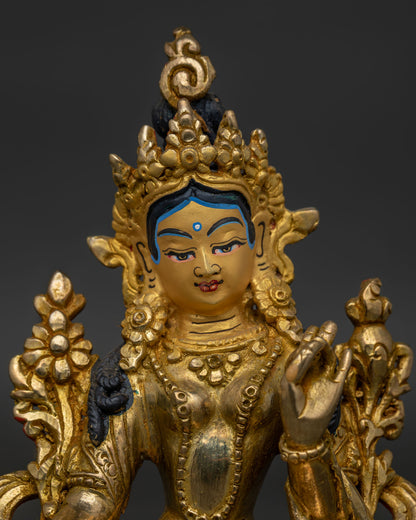 Close up of Green Tara statue with gold painted face and traditional Himalayan craftsmanship