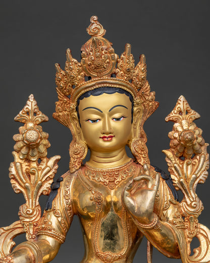 Close up of Green Tara Statue with gold painted face floral carvings