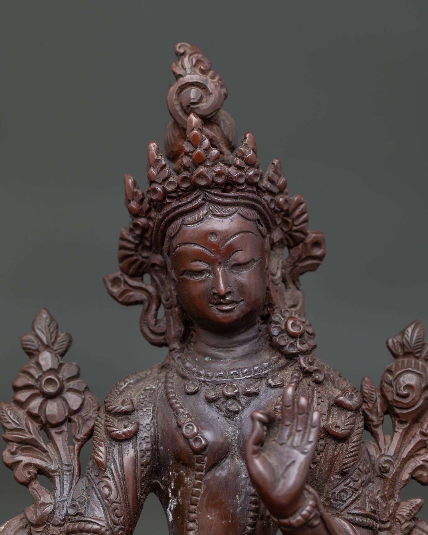 Close up of Green Tara Statue with serene face oxidized copper and hand carved jewelry.
