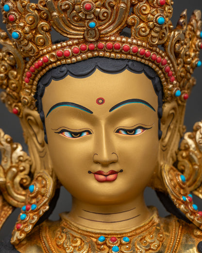 Close-up of Green Tara statue's serene gold-painted face and crown detail