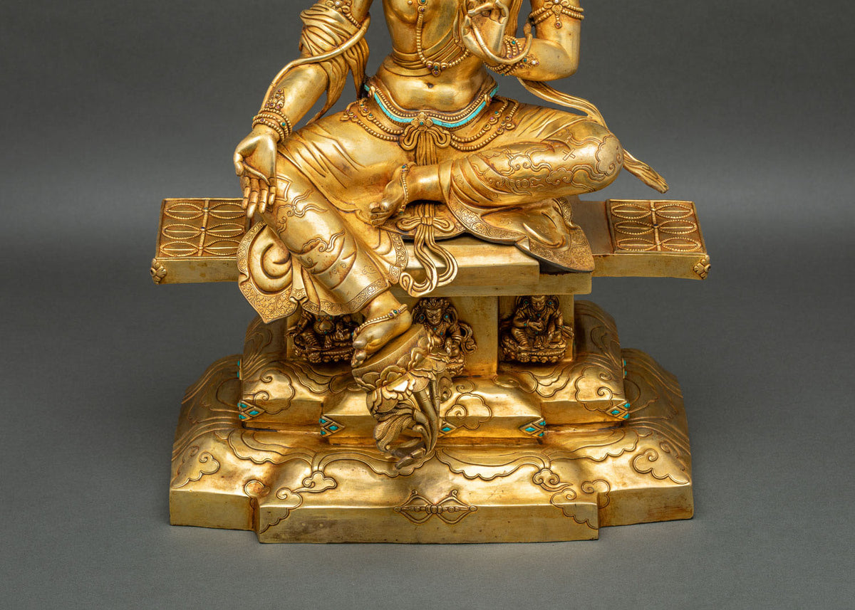 Close-up of Green Tara throne base with three Dzambhala figures, turquoise inlay and carved beams