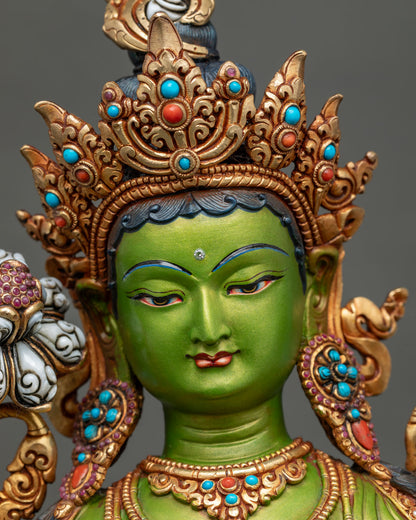 Close-up of Green Tara’s serene face, forehead bindi and ornate gold headdress