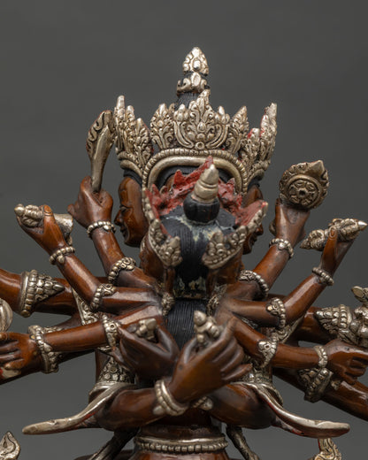 Close-up of Guhyasamaja statue’s multiple arms and ornate silver crown in oxidized copper