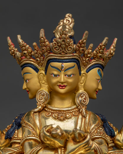 Close up of Guhyasamaja statue with three heads and radiant gold painted face