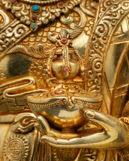 Close-up of Guru Rinpoche left hand holding kapala with sacred nectar vase detail