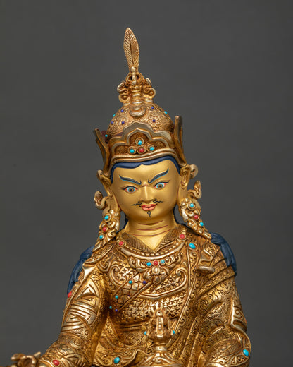 Close up of Guru Rinpoche statue showing gold fire-gilded robe, crown and turquoise coral inlays