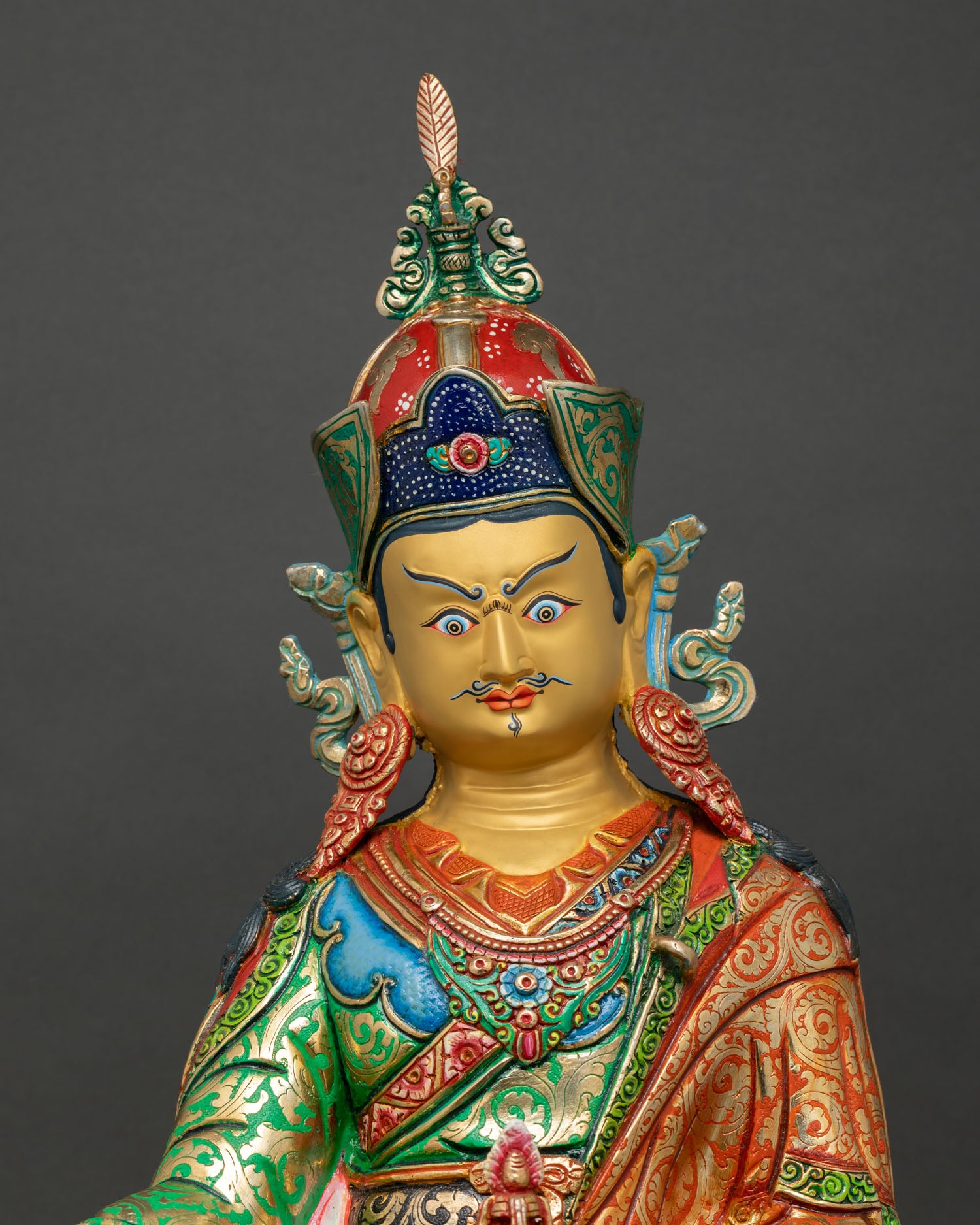 Close up of Guru Rinpoche statue showing intricate lost-wax copper details and gold gilded craftsmanship