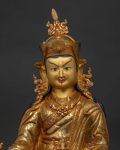 Close up of Guru Rinpoche Statue with gold painted face and intricate floral robe carvings
