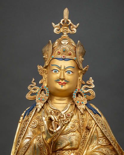 Close up of Guru Tsokye Dorje statue with turquoise and coral inlay on crown and gold fire-gilded robe