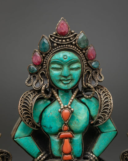 Close-up of hand-carved turquoise Amitayus face with gemstone crown and coral vase pendant