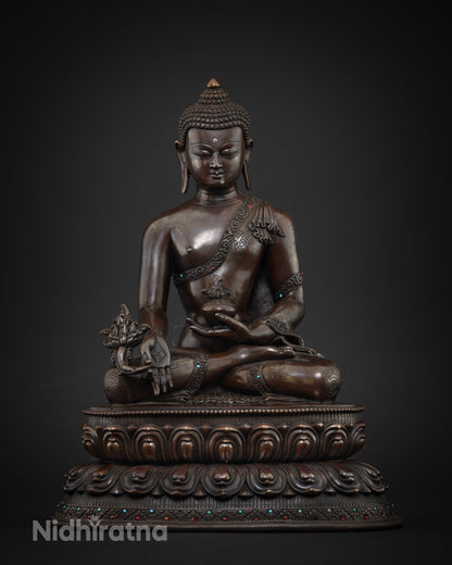 Close up of handcrafted copper Medicine Buddha statue with lotus base and semi-precious stones