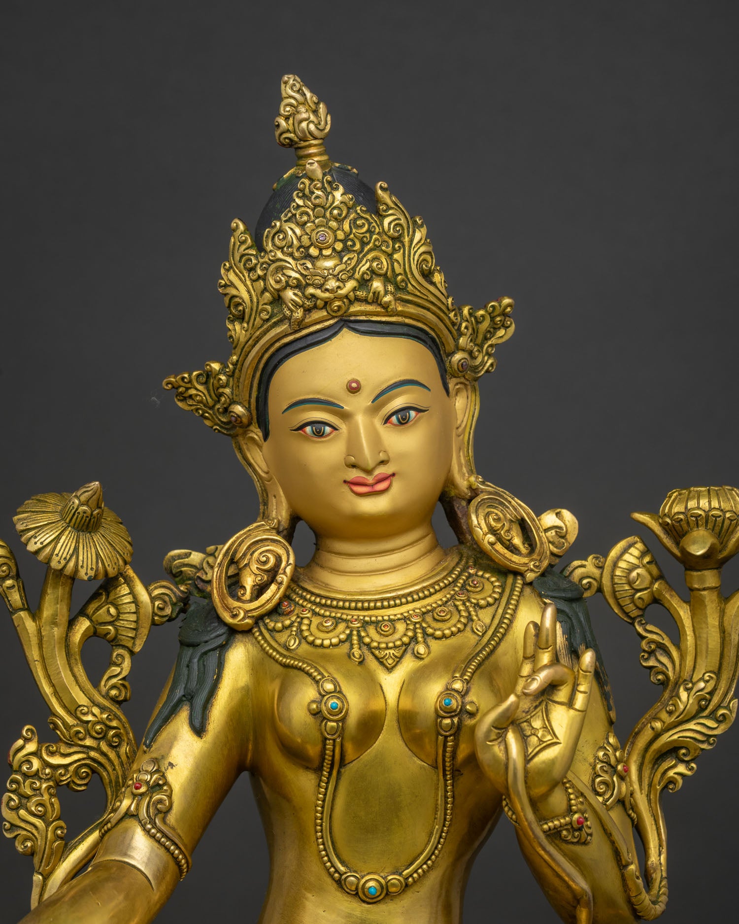 Close up of handcrafted Green Tara statue showing 24K gold finish and jewelry.