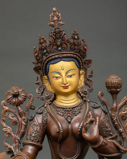 Close up of handcrafted Green Tara statue with oxidized copper finish and lotus throne