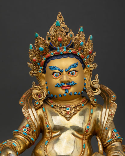Close up of handcrafted Jambhala Statue with gold gilding turquoise coral and ornate Buddhist details