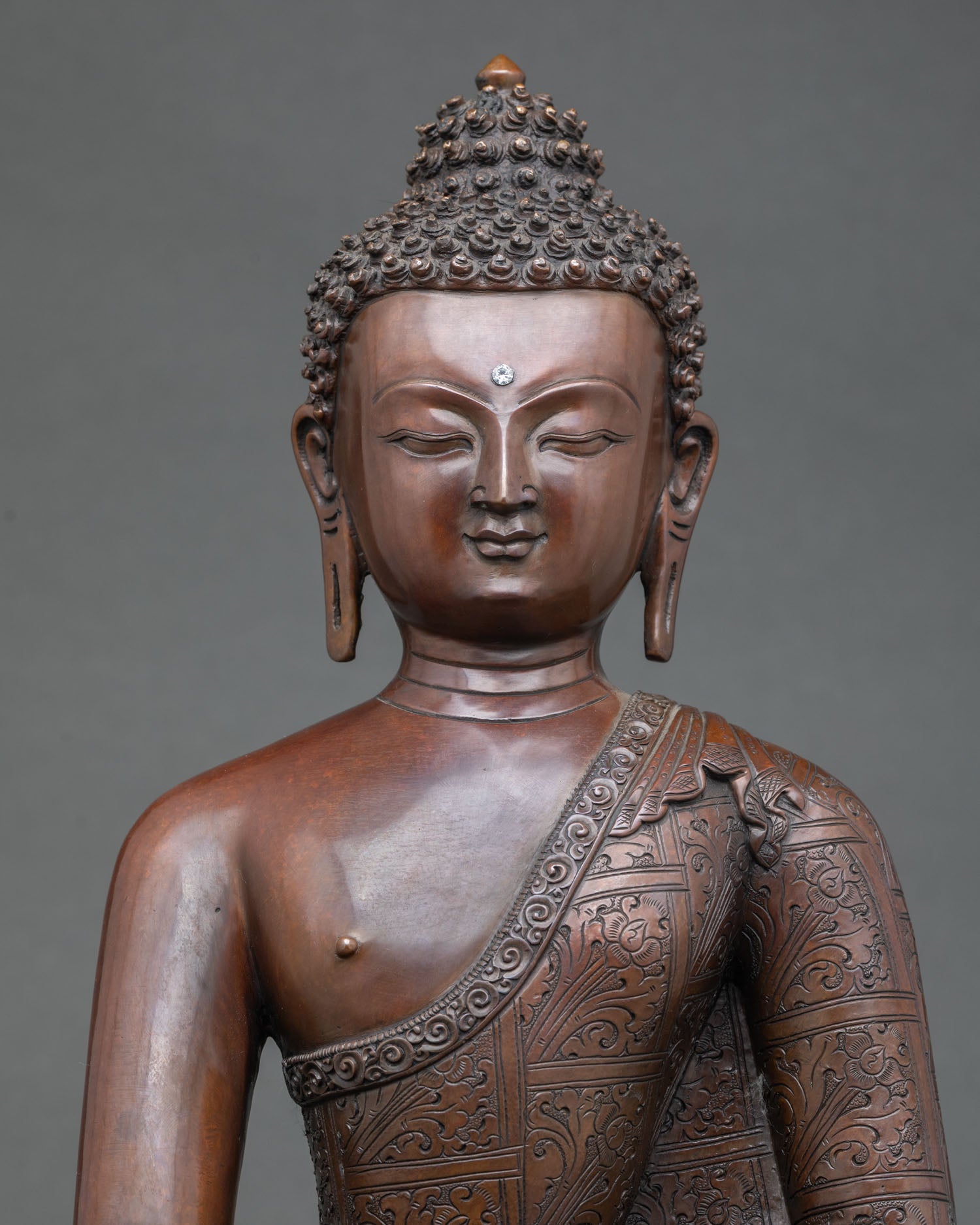 close up of handcrafted shakyamuni buddha figurine with oxidized copper finish