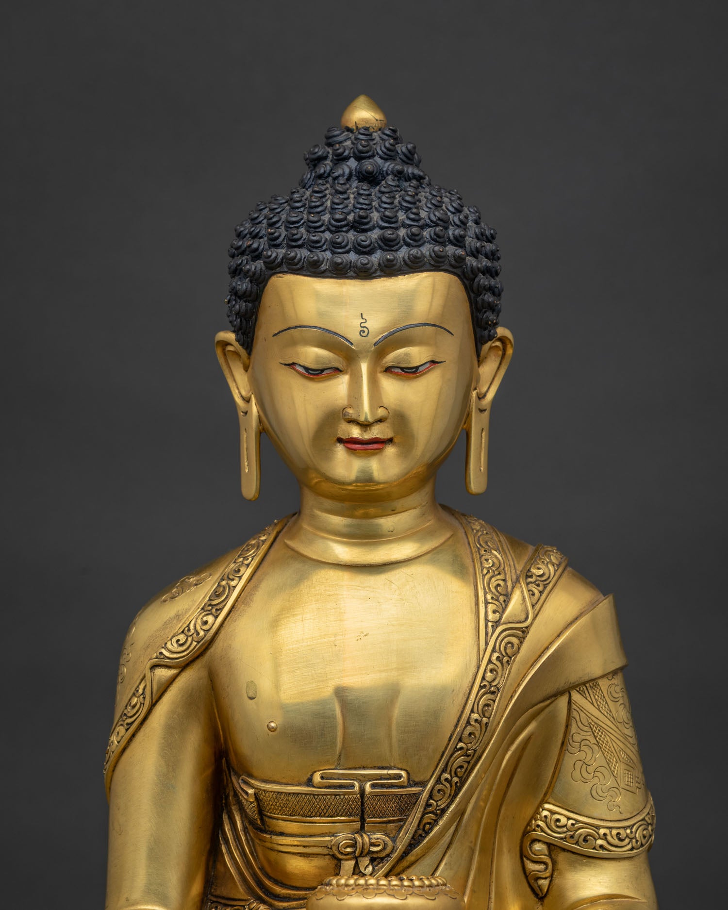 close up of handcrafted shakyamuni buddha statue with ashtamangala carved robe nepal