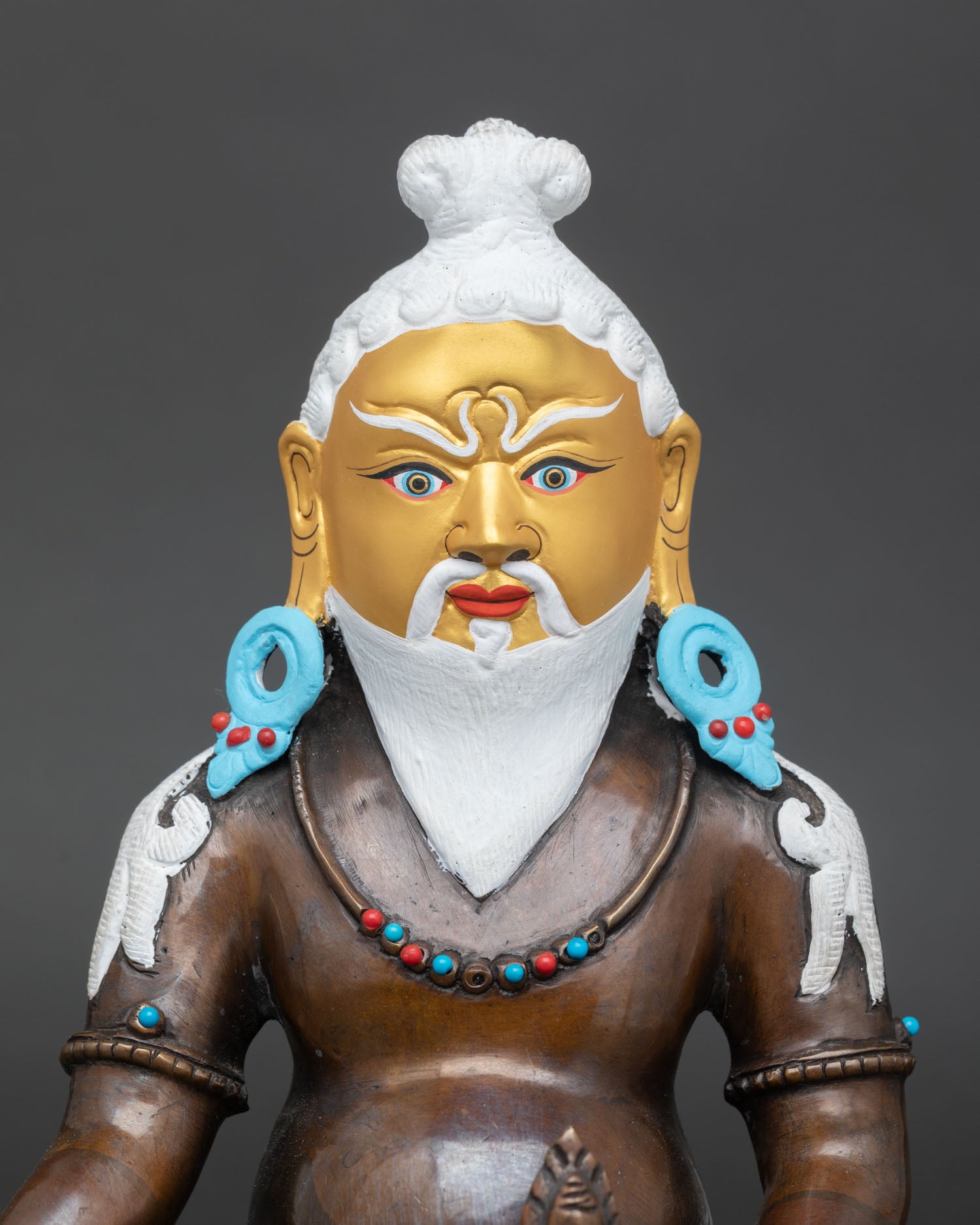 Close-up of handcrafted Thangtong Gyalpo statue in oxidized copper with stone accents