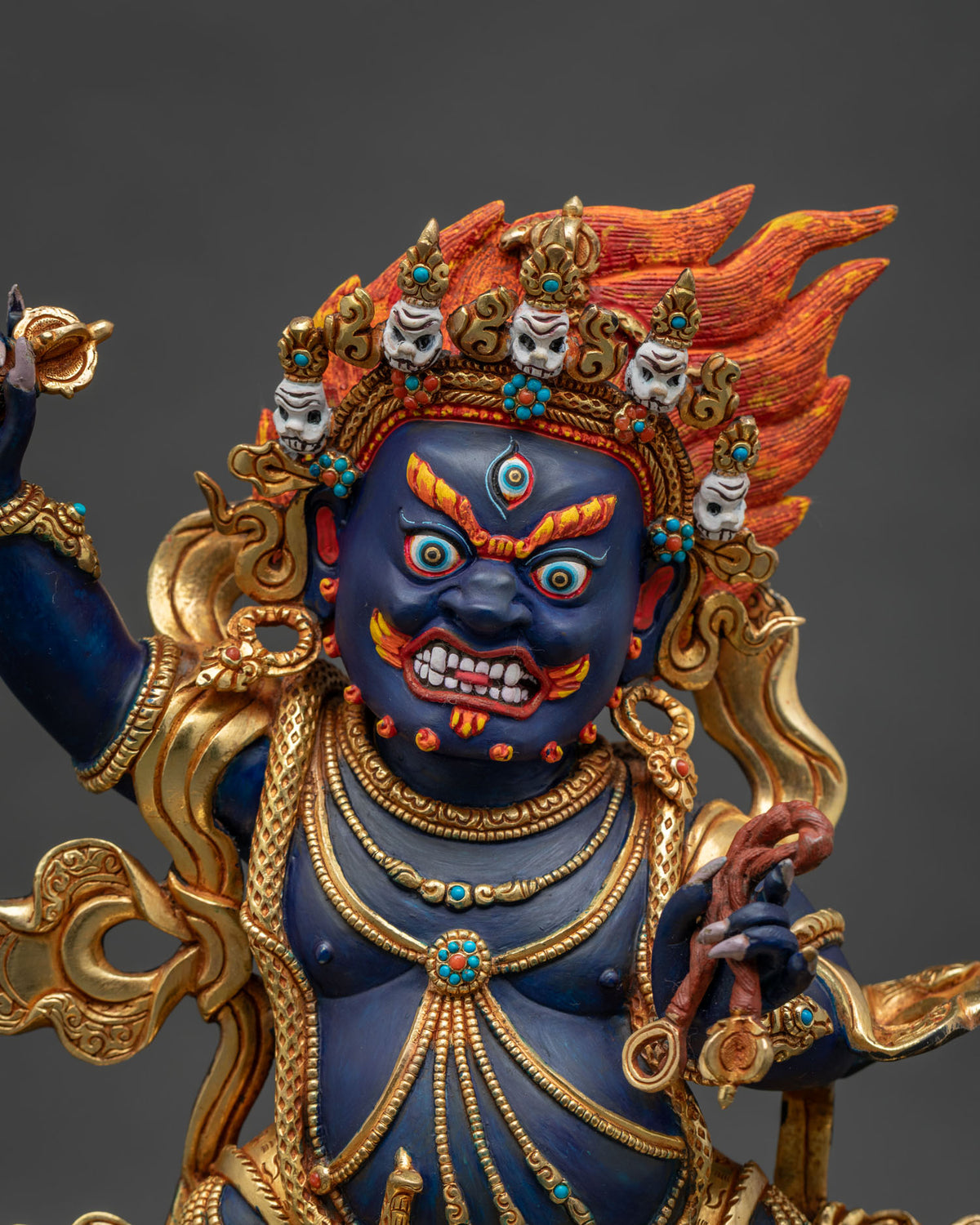Close-up of handcrafted Vajrapani Buddhist statue with gold gilding and gemstone details