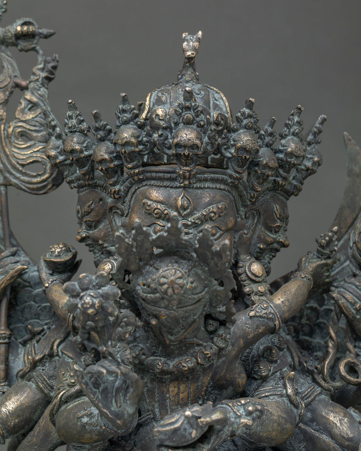 Close-up of Hayagriva bronze statue crown with skulls, horse head finial, and wrathful face detail